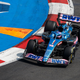 A photo of Fernando Alonso driving a blue Alpine F1 car in Mexico.